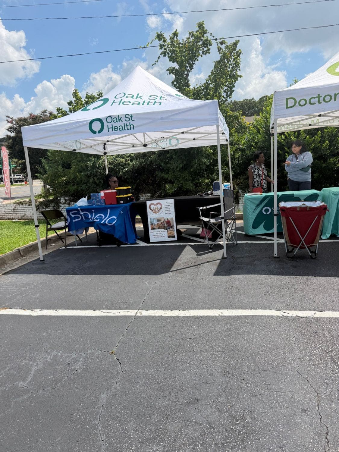 Healthcare Support Home Care's free blood pressure check table under the Oak Street Health tent at the East Point food pantry community outreach event
